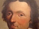 portrait of a man in a white collared shirt and a black and white collar