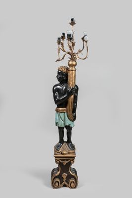 paire de figurines noires et dorées représentant un homme tenant un candélabre