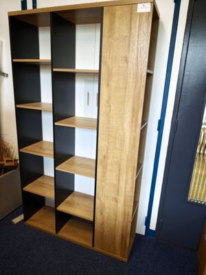une grande bibliothèque en bois dans un coin de la pièce