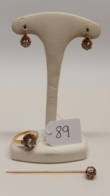 un gros plan sur deux bagues et une paire de boucles d'oreilles posées sur un présentoir