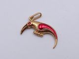 an image of a gold and red bird charm on a white surface