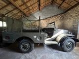 un camion militaire garé dans un bâtiment au toit en bois