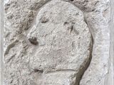 relief représentant le visage d'un homme sur un bloc de pierre