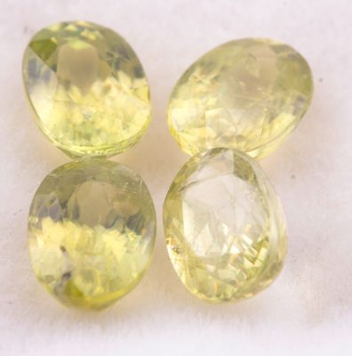 trois saphirs jaunes posés sur une surface blanche