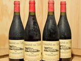 trois bouteilles de vin sont posées sur un tonneau en bois devant un mur en bois