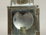 a silver lantern with a light on top of it