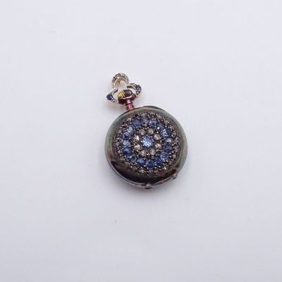 un gros plan d'un pendentif orné d'une pierre bleue et blanche