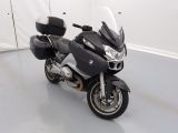 une moto noire et argentée garée dans une pièce blanche