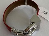a red leather bracelet with a silver buckle on it