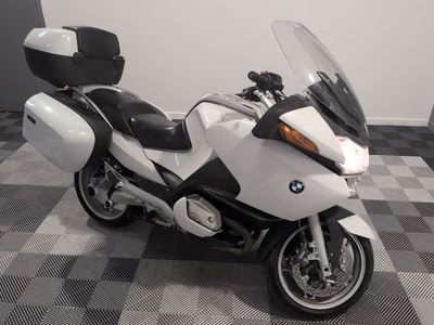 une moto garée sur un sol en carrelage à damier dans une pièce