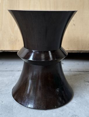 un tabouret noir avec un piètement en bois dans une pièce