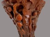 a close up of a wooden vase with a carved design on it