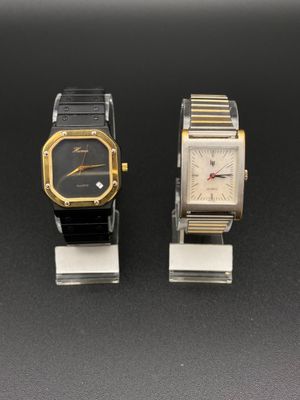 Deux montres sont posées côte à côte sur une surface noire