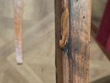 a close up of a wooden table with a red chair in the background