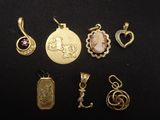 a close up of a collection of gold jewelry on a black surface