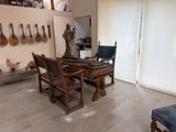 a room with a table, chairs, and guitars on the wall