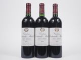 trois bouteilles de vin rouge posées l'une à côté de l'autre sur une surface blanche