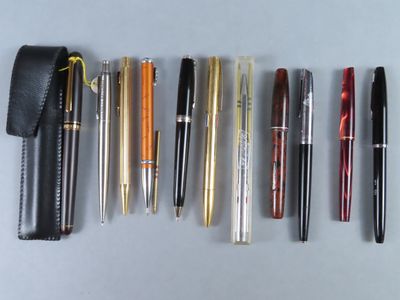 de nombreux stylos et crayons de toutes sortes alignés sur une table