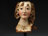 a carved head of a woman wearing a brown dress