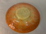 a yellow and orange bowl sitting on a white surface