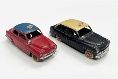 deux voitures jouets assises l'une à côté de l'autre sur une surface blanche