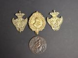 trois médailles d'or et une pièce de monnaie posées sur un fond noir