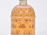 une petite bouteille en verre ornée d'un motif doré