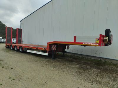 a flatbed trailer parked in front of a building