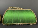 two green and gold purses on a black background