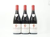 trois bouteilles de vin rouge posées sur une table blanche