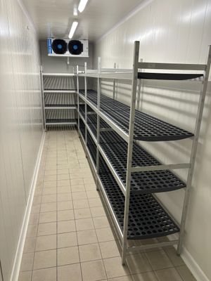 une longue étagère métallique au milieu d'une pièce