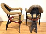 pair of wicker chairs on wooden floor in a room with white walls