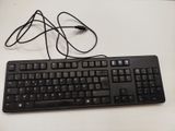 a black keyboard and mouse sitting on a white table