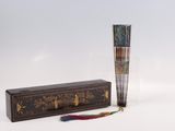incense sticks in a wooden box with a tassel on a white background