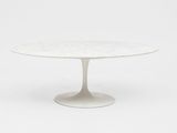 une table en marbre blanc avec un piètement circulaire et un socle blanc