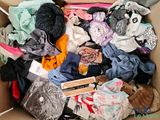 a cardboard box filled with clothes and other items