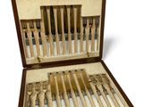 a wooden case with a set of knives and forks in it