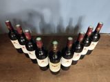 several bottles of wine are lined up on a wooden table