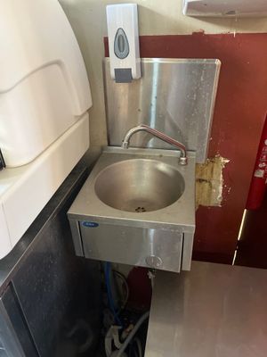 a sink in the corner of a small room