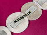 a close up of a necklace with a pin on it