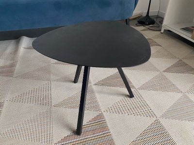 a black table with a black top sitting on a carpet