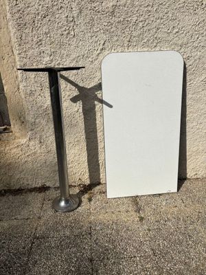 un tableau blanc posé à côté d'une table sur le trottoir