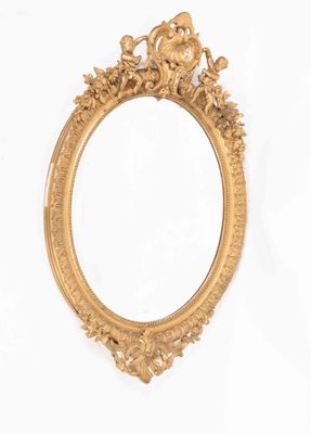 MIROIR ovale biseauté dans un cadre en bois et stuc doré, à …