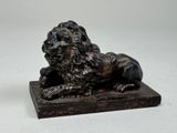 une statue représentant un lion assis sur un socle