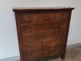 une commode ancienne dans une pièce recouverte de moquette