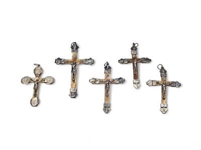 On voit trois croix métalliques sur fond blanc