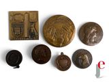 plusieurs types de pièces de monnaie et une médaille posées sur une surface blanche