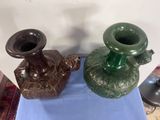 two vases sitting on a blue table next to each other