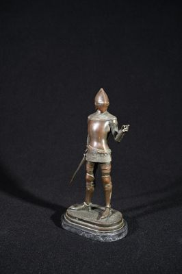 une figurine antique en bronze représentant un chevalier tenant une épée