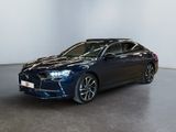 une voiture bleue garée dans une grande pièce aux murs blancs